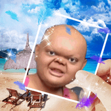 a person is holding a picture of a baby with a beach in the background