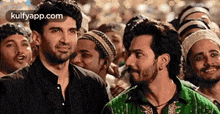 two men are standing next to each other in a crowd .