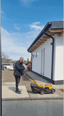 a man is standing next to a stiga lawn mower