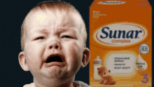 a baby is crying in front of a box of sunar complex 3