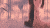 a blurred image of a person walking through a forest with trees in the background .