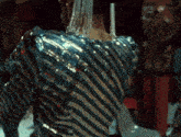 a woman wearing a striped top with sequins on the back
