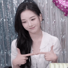 a woman in a white shirt giving a thumbs up sign