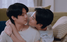 two young men are hugging each other and looking at each other