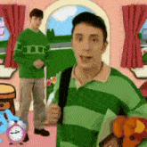 a man in a green and white striped shirt is holding a book