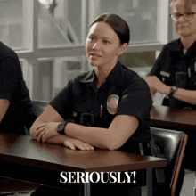 a woman in a police uniform sits at a desk with seriously written in the corner