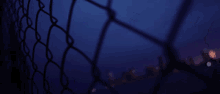 a blurry picture of a chain link fence with a red white and blue glitch effect behind it