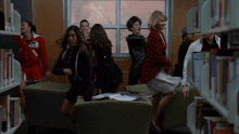 a girl in a red jacket with the letter m on it is dancing