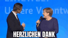 a man and a woman are standing next to each other on a stage . the woman is holding a microphone .