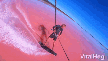a man is riding a wave on a surfboard with viralhog written on the bottom right