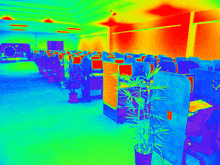 a room with a lot of cubicles and a plant