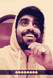 a man with a beard is wearing a hoodie and a hat
