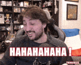 a man sitting in front of a microphone with the words ' hahahaha ! ' written on his face