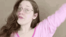 the woman is wearing glasses and a pink shirt .