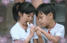 a boy and a girl are eating ice cream together while holding hands .