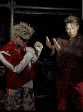 a man in a red jacket is giving another man a high five .
