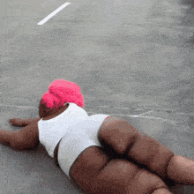 a woman with pink hair and white shorts laying on the ground