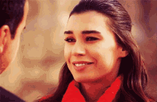 a woman in a red scarf smiles at a man