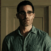 a man wearing glasses and a green shirt