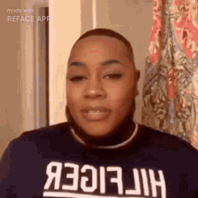 a man with a beard is wearing a tommy hilfiger shirt and a turtleneck .