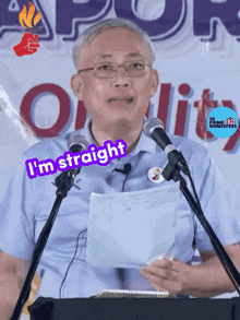 a man is giving a speech and says " i 'm straight " in front of two microphones