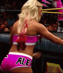 a woman in a wrestling ring is wearing pink shorts that say ale