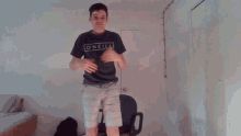 a young man wearing a oneill t-shirt is dancing in a room