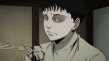 a boy with a scary face is holding chopsticks in his hand