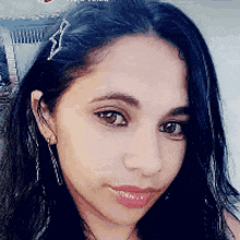 a close up of a woman 's face with earrings and a hair clip