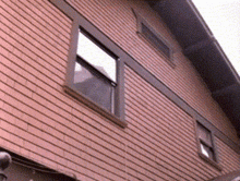 a brick building with a few windows and a roof