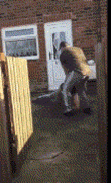 a man is standing in front of a brick house with a white door
