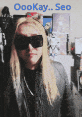 a man with long blonde hair wearing sunglasses and a black jacket with the words oookay seo written above him