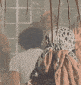 a woman in a leopard print jacket is standing in a room with other women