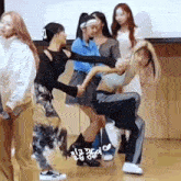 a group of women are standing next to each other on a floor .