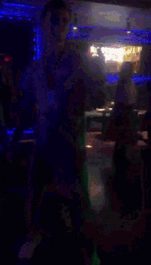 a man is dancing in a dark room with a green light behind him