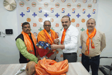 a man in an orange scarf is giving a bouquet of flowers