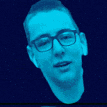 a man wearing glasses and ear buds is in a blue light