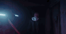 a man in a black jacket is walking through a dark room with a caution tape .