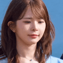 a close up of a woman 's face with a blue sky behind her