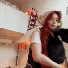a woman with red hair is holding a black cat in her arms .