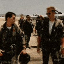 a group of men in military uniforms are walking on a runway ..