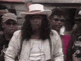 a man wearing a cowboy hat is surrounded by other men