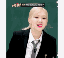 a woman in a suit and tie is smiling in front of a sign that says ' spring '