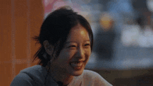 a woman is smiling and looking at the camera