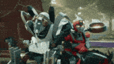 a couple of robots standing next to each other in front of a red barn .