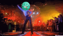a pixelated image of a man dancing with a green smiley face on his head