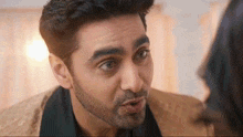 a man with a beard is looking at a woman and making a face .