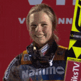 a smiling woman wearing a jacket that says narime on it