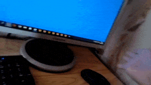 a computer monitor with a blue screen and a keyboard