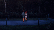 a couple of people standing on a sidewalk with trees in the background